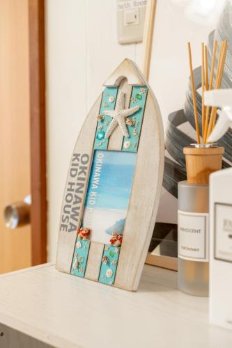 a wooden surfboard shaped ornament on a table at Type B Room 27平米 - ウル エスポワール那覇2- in Kume