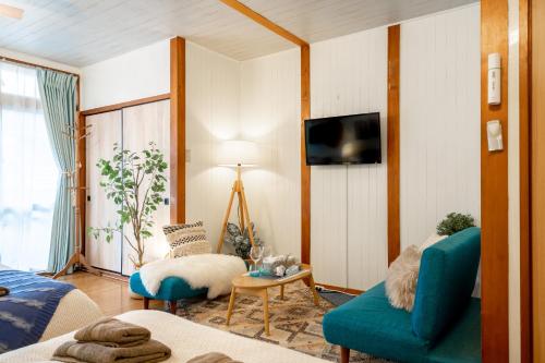 a living room with a blue couch and a tv at Type B Room 27平米 - ウル エスポワール那覇2- in Kume