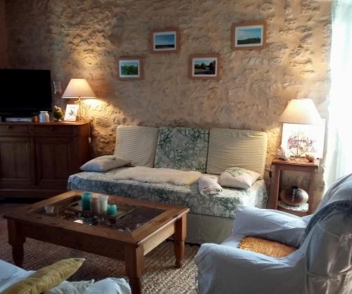 a living room with a couch and a coffee table at Gîte de Charme Robineau Eco-Logis Gironde in Caumont