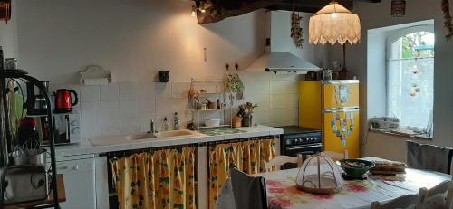 a kitchen with a sink and a table with a tableablish at Gîte de Charme Robineau Eco-Logis Gironde in Caumont