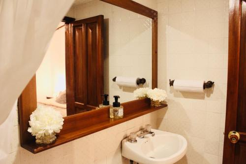 een badkamer met een wastafel en een spiegel bij Casa de hospedaje Vivaio in Paipa