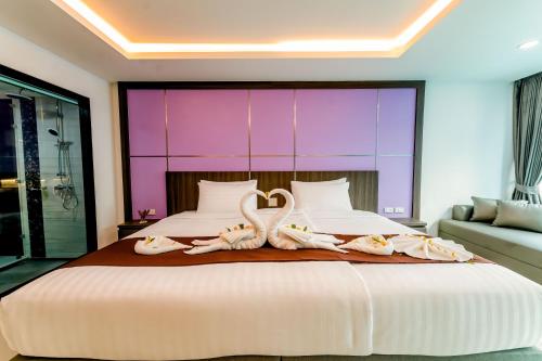 a bedroom with a large bed with swans on it at The Proud Hotel Pattaya - SHA Certified in Pattaya North