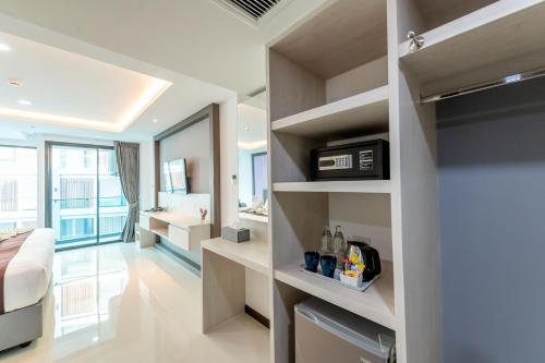 a room with a bedroom with a bed and a bathroom at The Proud Hotel Pattaya - SHA Certified in Pattaya North