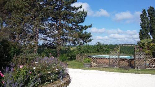 a garden with a pool and a fence and flowers at Gîte de Charme Robineau Eco-Logis Gironde in Caumont
