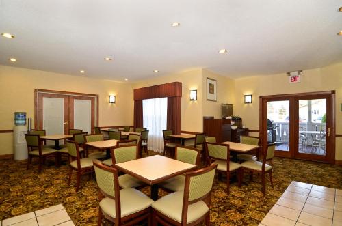 a restaurant with tables and chairs in a room at Country Inn & Suites by Radisson, Stevens Point, WI in Stevens Point
