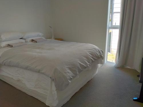 a white bed in a room with a window at Lake Tekapo Double Room shared facilities in Lake Tekapo