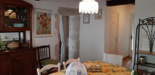 a dining room with a table and a chandelier at Gîte de Charme Robineau Eco-Logis Gironde in Caumont