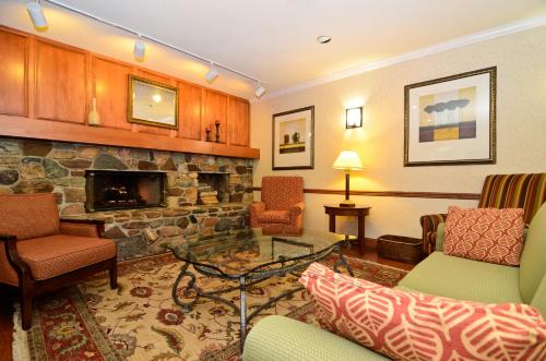 a living room with chairs and a stone fireplace at Country Inn & Suites by Radisson, Stevens Point, WI in Stevens Point