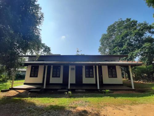 a small house with a blue roof on a field at Katagamuwa Rest in Kataragama