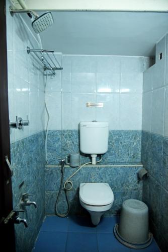 a bathroom with a toilet and a shower at Grand Choice in Bangalore