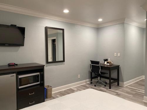 a room with a desk and a television and a chair at Aura Inn Monterey in Monterey