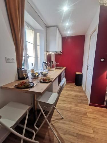 a kitchen with a table with plates of food on it at Les appartements du centre, refaits à neuf, climatisés, hyper centre, 50m à pieds des commerces, restaurants, parking gratuit in Salies-de-Béarn