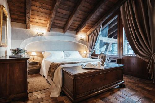 a bedroom with a large bed and a large window at Relais Mont Blanc Hotel & Spa in La Salle