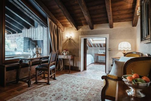 a living room with a table and chairs and a kitchen at Relais Mont Blanc Hotel & Spa in La Salle