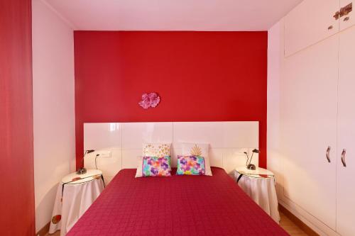 1 dormitorio rojo con 1 cama con pared roja en Unsejouraempuriabrava-TERRASSE-VUE MER -CLIME- WIFI PARKING, en Empuriabrava
