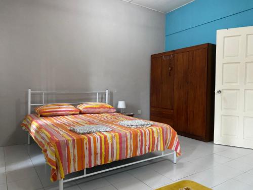 a bedroom with a bed and a wooden cabinet at Aziym Homestay@Bandar Baru Bangi in Kampong Tangkas