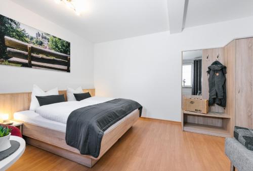 une chambre avec un grand lit et une chaise dans l'établissement Am Landhof Ferienwohnung, à Heilbad Heiligenstadt