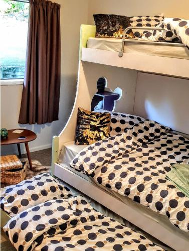 a bedroom with two bunk beds and a table at Unique Estuary & Bird Apartment in Te Haumi Paihia in Paihia