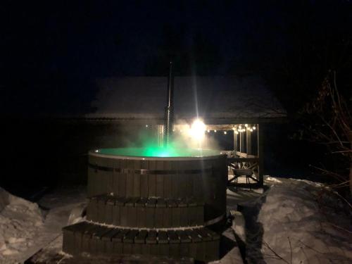 a light in a barrel in the snow at night at Dzirnavkalns in Cesvaine