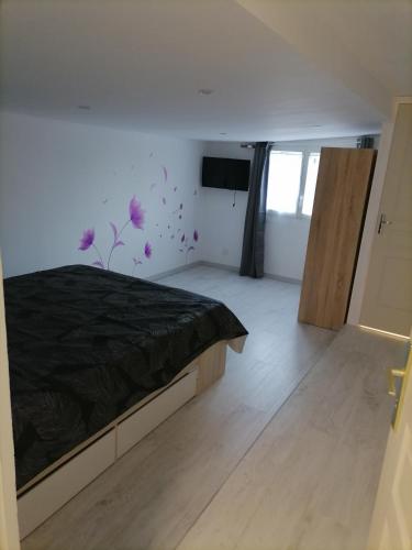 - une chambre avec un lit orné de fleurs violettes sur le mur dans l'établissement Gîtes aux cœurs des vignes a 10mm du zoo de beauval 3 étoiles, à Mareuil-sur-Cher