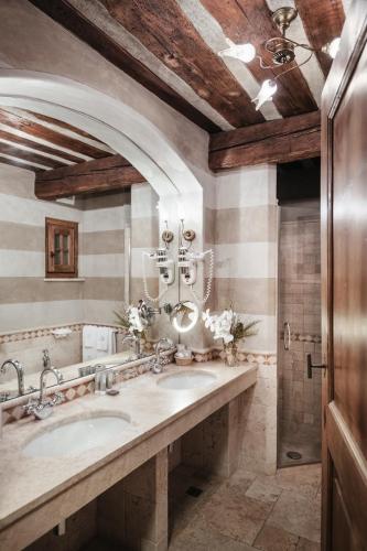 a bathroom with two sinks and a large mirror at Relais Mont Blanc Hotel & Spa in La Salle