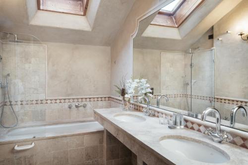 a bathroom with two sinks and a shower and a tub at Relais Mont Blanc Hotel & Spa in La Salle