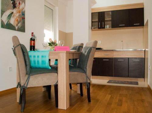 einen Esstisch mit Stühlen und eine Küche in der Unterkunft Apartman Soko in Sokobanja