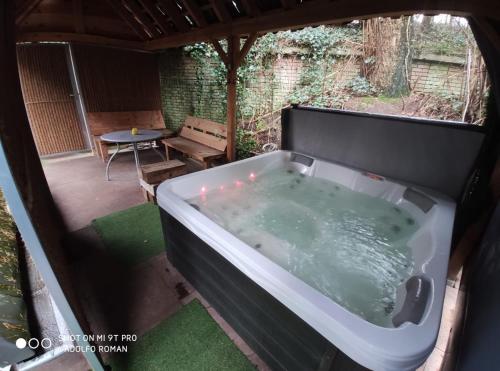 a bath tub in a yard with a table at Vakantiehuis met sauna en jacuzzie in Lunteren