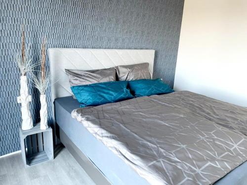 a bed with blue pillows on it in a bedroom at Ferienwohnung Strandkieker 2 in Ueckermünde