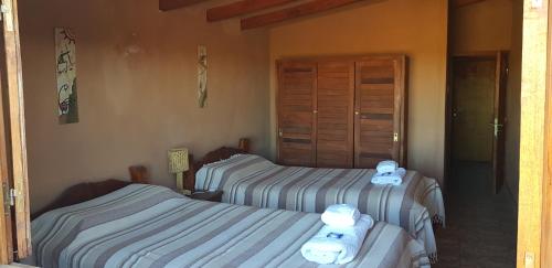 Dos camas en una habitación con toallas. en Complejo Pucara en Antofagasta de la Sierra
