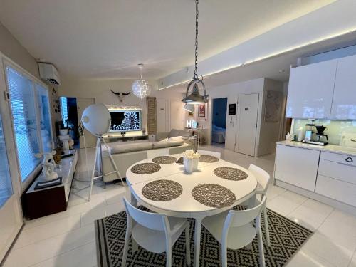 a kitchen and living room with a white table and chairs at Design Guesthouse Laanila in Oulu