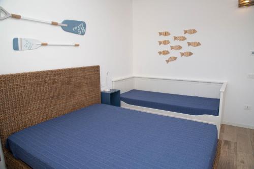 a bedroom with two beds with blue sheets and a wall at Casalina in Lido di Jesolo