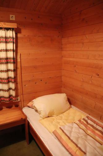 a small bed in a wooden room with a window at Landhaus/Holzhaus in Bad Wünnenberg