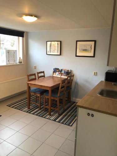 a kitchen with a wooden table and chairs and a sink at B&B Kleine Vliet in Medemblik