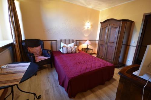 a bedroom with a red bed and a chair at Pension zur Königlichen Ausspanne Dresden in Dresden