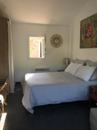 a bedroom with a large white bed and a window at LA PASSIFLORE in La Londe-les-Maures