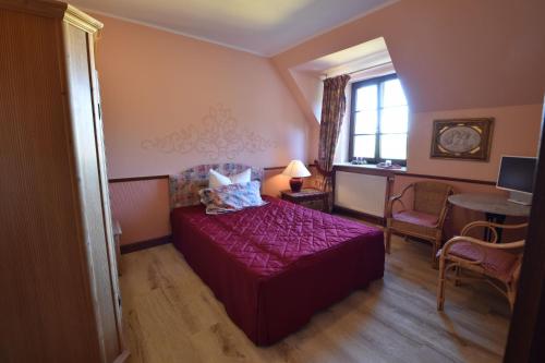 a bedroom with a purple bed and a window at Pension zur Königlichen Ausspanne Dresden in Dresden