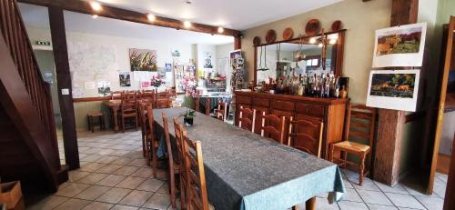 un restaurante con mesa, sillas y espejo en Le Fidèle, en Saint-Chamant