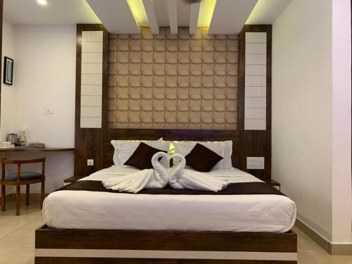 a bedroom with a bed with two white towels at THE PORCH INN in Wayanad