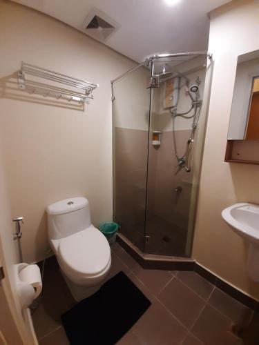 a bathroom with a shower and a toilet and a sink at 1Tagaytay in Lipa