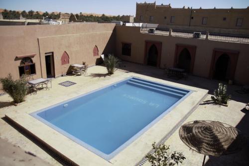 a large blue swimming pool on top of a building at Auberge La Source in Merzouga