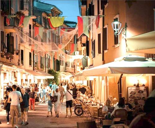 a group of people walking down a city street at Appartamento Orchidea Garda in Garda