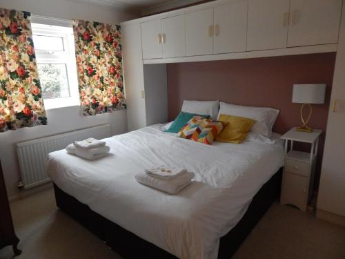1 dormitorio con 1 cama blanca grande y toallas. en Two bedroom corporate and family stay with parking in popular location, en Cambridge