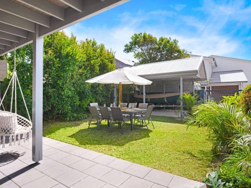a patio with a table and chairs and an umbrella at Rangoon Sunrise at Minnamurra in Minnamurra