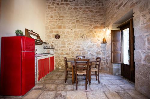 a kitchen with a red refrigerator and a table at IzzHome Carrubo in Santa Croce Camerina