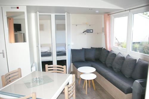 a living room with a couch and a table at MHVACANCES LOUENT PLUSIEURS MOBILHOMES DANS CAMPING 4 ETOILES PROCHE CHATEAUX et ZOO BEAUVAL in Onzain