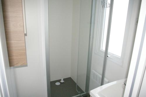 a small bathroom with a shower and a sink at MHVACANCES LOUENT PLUSIEURS MOBILHOMES DANS CAMPING 4 ETOILES PROCHE CHATEAUX et ZOO BEAUVAL in Onzain