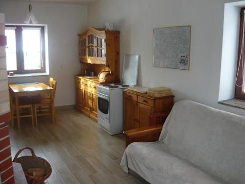 uma cozinha com um sofá e uma mesa num quarto em Wichrowe Wzgórze em Dynów