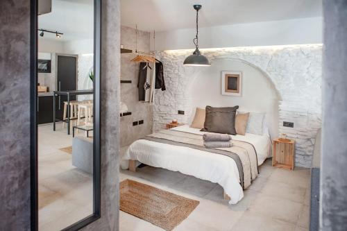 1 dormitorio con cama y pared de piedra en 11 - LA GUARIDA DE TARIFA - Segundo A - ENJOY TARIFA, en Tarifa