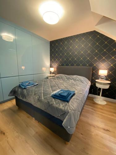 a bedroom with a bed with blue towels on it at APARTAMENT KRYNICA MORSKA in Krynica Morska